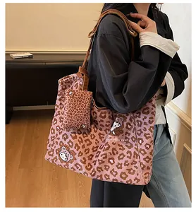 Dettaglio della borsa tote in tela leopardata con gatto a cartoni e pochette coordinata