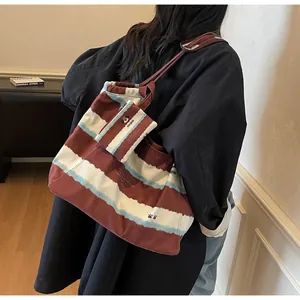 Dettaglio della borsa tote in tela a righe con stampa a cane e astuccio coordinato