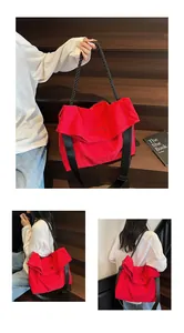 Macro detail of red nylon tote bag featuring oval cutout handle and rope shoulder straps