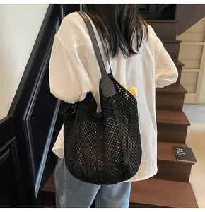 Detail einer schwarzen handgestrickten Netztasche mit verstärkten Leder-Schultergurten
