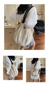 Detail der weißen handgefertigten Häkel-Tasche mit schwarzen Schulterriemen und Netzstruktur