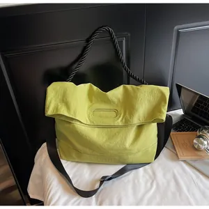 Detail of lime green tote bag showing the oval cutout handle and black braided rope grip