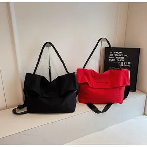 Detail of large tote bags in black and red with woven handles and adjustable nylon straps