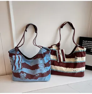 Dettaglio di borse tote in tela con stampe cartoon e piccoli borsellini coordinati