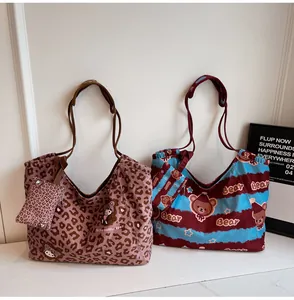 Dettaglio di grandi borse tote in tela con stampe di orsetti e motivi leopardati