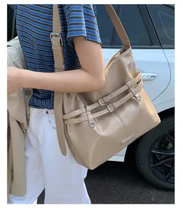 Detailansicht beige Schultertasche mit verstellbaren Schnallen und Metall-Bodendetails