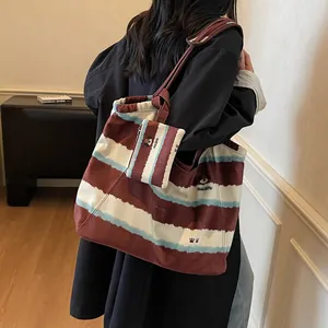 Grande borsa tote in tela a righe bordeaux con ricamo cane portafortuna e pochette coordinata