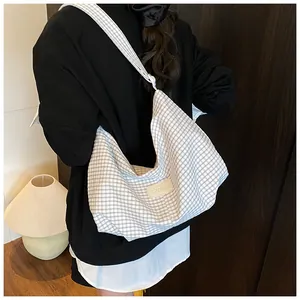 Detail of black and white checkered canvas tote with beige leather brand patch