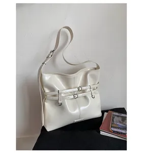 Nahaufnahme der cremeweißen Lackleder-Schultertasche mit Schnallen und Silberbeschlägen