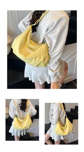 Detail of yellow nylon tote bag with TZIMEI label and soft pleated fabric texture