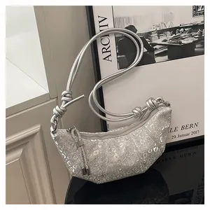 Detail der silbernen Pailletten-Hobo-Tasche mit Tiermuster-Struktur und Knotendesign