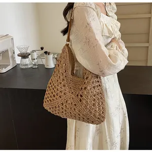 Détail du tissage au crochet et de la bandoulière en cuir sur le sac fourre-tout en paille