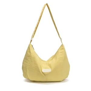 Large pale yellow crescent shoulder bag in quilted nylon fabric with TZIMEI label