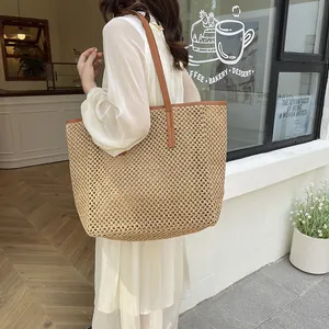 Chic woven straw tote bag with brown leather handles for summer travel and beach vacations