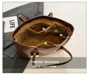 Interior of large brown leather tote showing striped lining and functional pockets