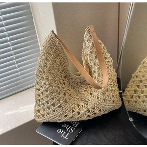 Détail du sac cabas en paille avec crochet beige ajouré et bandoulière en cuir marron