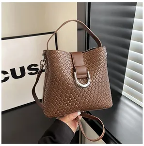 Detailaufnahme der braunen gewebten Beuteltasche mit Textur und silberner D-Ring-Schnalle