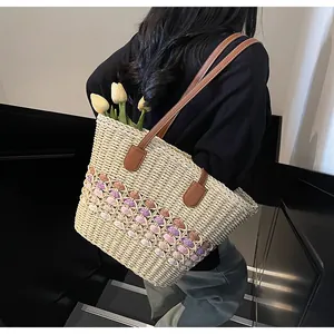 Detail of handmade straw tote bag with colorful hollow weave and brown leather handles