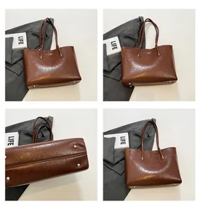 Detail view of dark brown textured leather tote bag with protective metal base feet
