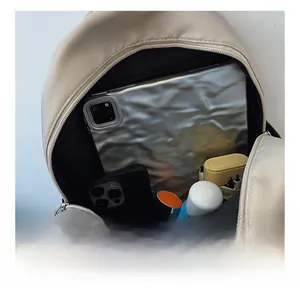 Macro view showing high capacity interior of the apricot nylon backpack with multiple items