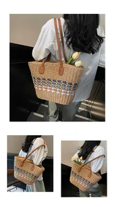 Detail of hand-woven straw tote with gradient blue cut-outs and brown leather straps