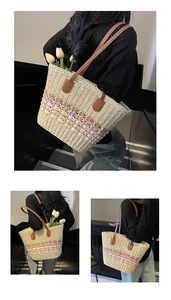 Detail of handmade woven straw tote featuring colorful 3D pom-poms and brown leather handles