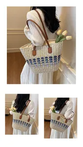 Detail of hand-woven straw tote with blue gradient pattern and brown leather straps