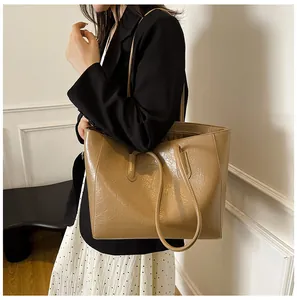 Detail of large tote bag with glossy wrinkled texture leather styled on a model