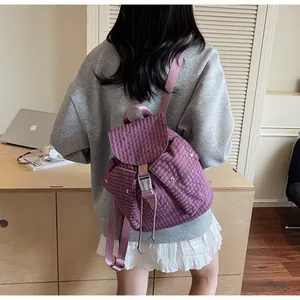 Detail view of purple checkerboard nylon backpack with flap closure and side pockets