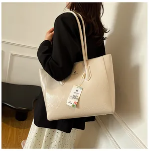 Detail shot of beige tote bag with oily leather texture and kangaroo logo embroidery