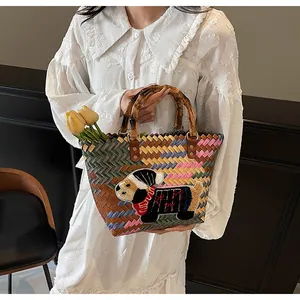 Close-up of woven tote bag featuring a cute dog patch and natural bamboo handles