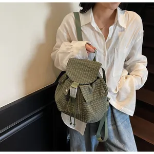 Detail of plaid canvas backpack with olive green check pattern and buckle closures
