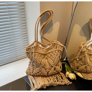 Détail du sac cabas bohème en paille avec tissage ajouré et longues franges élégantes