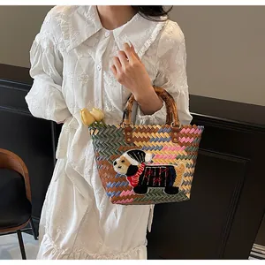 Handcrafted woven tote bag with colorful patterns and unique natural bamboo handles