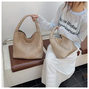Gros plan de sacs hobo tressés dorés champagne en grandes et petites tailles effet métallisé