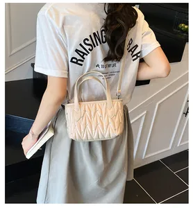 Detail of beige quilted mini crossbody bag with shimmering rhinestone embellishments