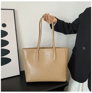 Close-up of khaki tote bag with pleated texture and thin shoulder straps for women