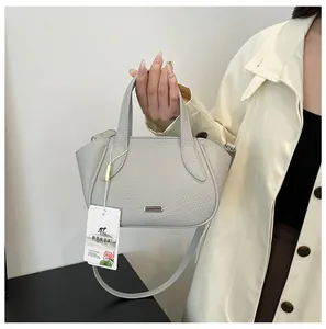 Detailansicht graue Handtasche aus Litschi-Leder mit Metallstreifen und Doppelgriffen