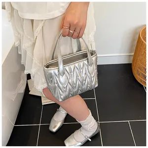Close-up of metallic silver quilted mini handbag with sparkling rhinestone accents