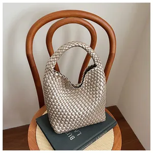 Gros plan sur la texture tressée champagne doré du sac hobo et sa poignée intégrée