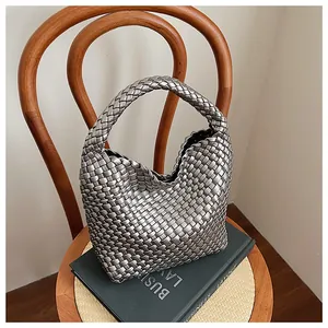 Gros plan sur la texture tissée argentée métallique et le motif à damier de ce sac à main