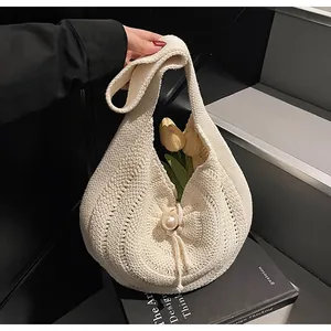 Detailed view of beige woven tote bag featuring an elegant oversized pearl buckle closure