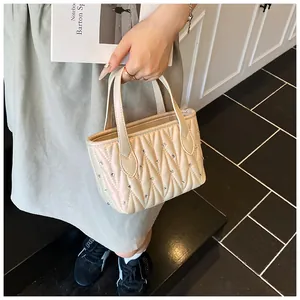 Detail of cream quilted handbag with rhinestone embellishments and elegant double handles