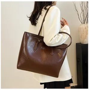 Detail of dark brown tote bag with pleated leather texture and sleek commute style