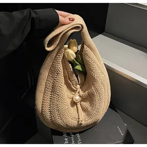 Detail of hand-woven crochet tote bag with hollow pattern and pearl drawstring buckle