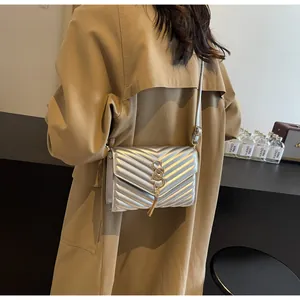 Detailansicht der silbernen Stepptasche mit goldener Schließe und Metallquastenanhänger