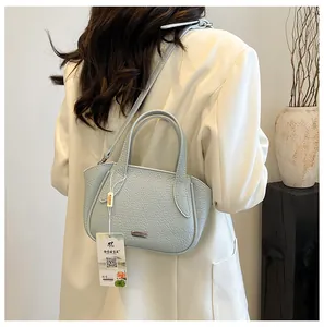 Nahaufnahme der hellblauen Handtasche aus Leder mit Metall-Logo und modischem Styling