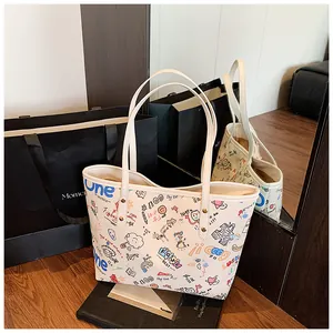 Detailed view of the colorful cartoon graffiti print and metal rivets on the white tote bag