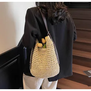 Straw woven shoulder bag with leather straps shown in a chic beach vacation lifestyle setting