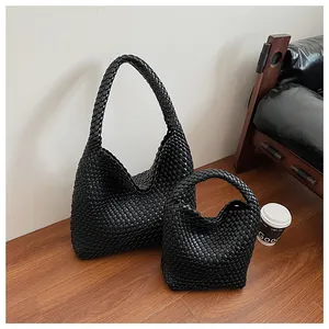 Détail des sacs cabas tressés noirs avec texture premium et petit sac à main assorti